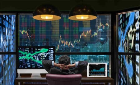 Relax man sits in front of screens witn trading charts